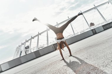 Sporda modern genç kadının tam boy amut açık havada egzersiz yaparken yaparken giyim