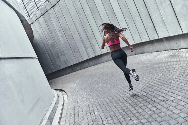 屋外で運動しながらジョギング スポーツウェアの若い女性の背面図 — ストック写真