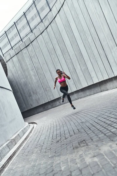 屋外で運動しながらジョギング スポーツウェアの若い女性の完全な長さ — ストック写真