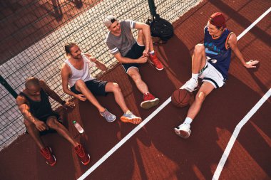 basketbol sahası üzerinde oturan genç sporcuların grup üzerinde üstten görünüm