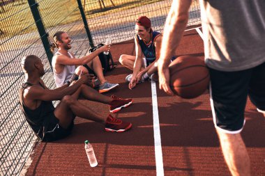 Mahkeme katta oturan ve rahatlatıcı basketbolcular 