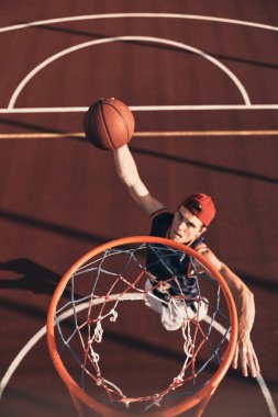 Best basketball player scoring slam dunk while playing basketball outdoors clipart