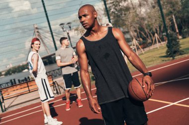 sportif Afrika man uzak arkadaşlar ile sahada basketbol topu tutarken arıyorum
