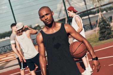 Kamera arka plan üzerinde arkadaşlarıyla basketbol sahası üzerinde dururken bakarak giyim spor Afrika delikanlı 