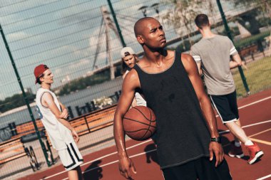 sportif Afrika man uzak arkadaşlar ile sahada basketbol topu tutarken arıyorum