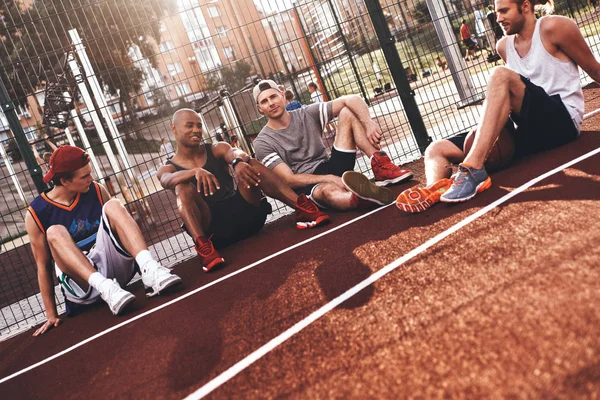 Grupo Jovens Desportistas Sentados Quadra Basquete — Fotografia de Stock