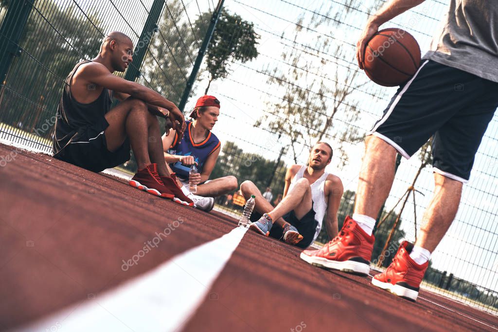 basketball  players sitting on court floor and relaxing, low angle view