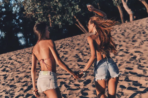 Vista Traseira Das Mulheres Shorts Swimwear Mãos Dadas Enquanto Corre — Fotografia de Stock