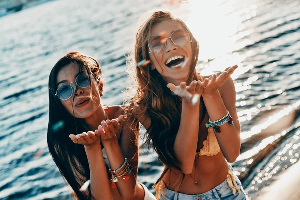 Two Attractive Young Women Blowing Confetti While Standing River — Stock Photo, Image