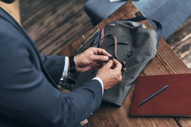 Moda Tasarımcısı Giyim Tasarım Stüdyosu masasında çalışırken kumaş renk örneği seçme yakın çekim 