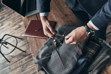 Moda Tasarımcısı Giyim Tasarım Stüdyosu masasında çalışırken kumaş renk örneği seçme yakın çekim 