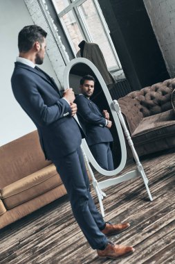 yakışıklı beyaz erkek takım elbise ceket atelier ve aynaya bakarak ayarlama 