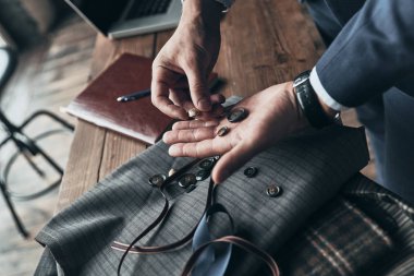 Moda Tasarımcısı Giyim Tasarım Stüdyosu çalışırken renk örneği ve düğmeleri kumaş seçimi yakın çekim