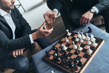 satranç oynamayı ve birbirlerine viski bardağı ile kızartma erkeklerin üstten görünüm
