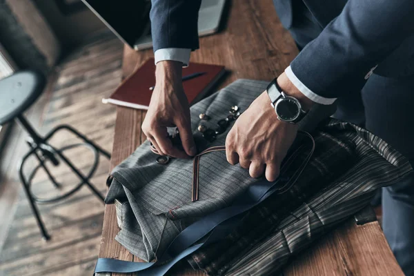 Moda Tasarımcısı Giyim Tasarım Stüdyosu masasında çalışırken kumaş renk örneği seçme yakın çekim 