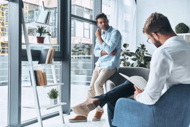 psikolog terapi seansı bakarak hayal kırıklığına uğramış genç adam