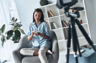 Genç kadın gösteren güzellik ürünü yeni video yapma, yeni kozmetik test ve video vlog kayıt sırasında 
