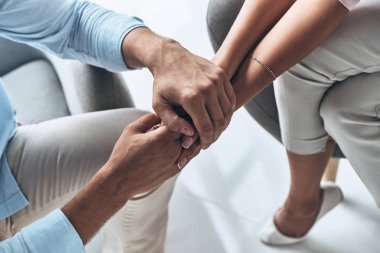 Sevgi dolu çift kapalı, otururken el ele tutuşarak kırpılmış görüntü el 