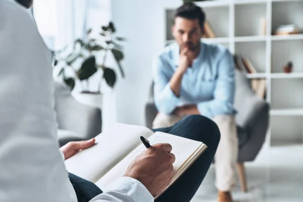 Mann Bei Therapiesitzung Mit Psychologe Teilsicht Des Arztes Schreibt Notizen — Stockfoto