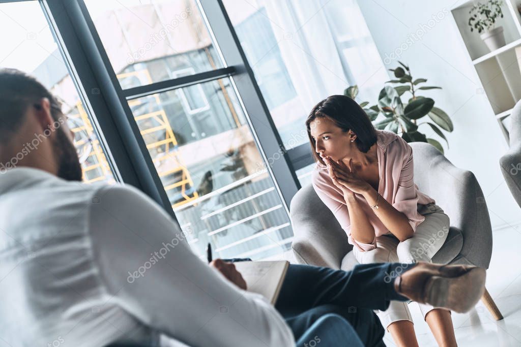 upset woman having therapy session with psychologist    
