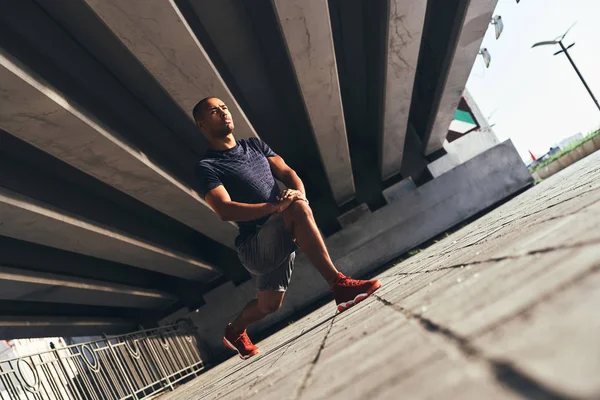 Mannen Sportkläder Stretching Benen Bron — Stockfoto