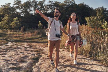 Elele ve açık havada yürürken gülümseyen bir çift