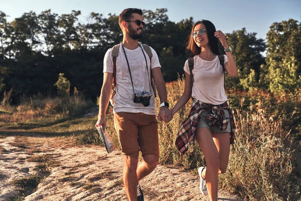 Elele ve açık havada yürürken gülümseyen güzel genç çift
