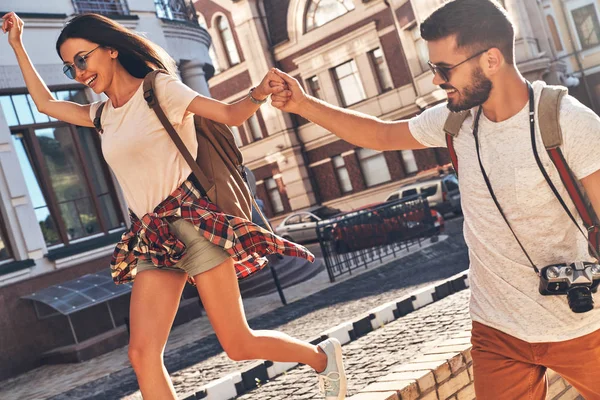 Elele ve açık havada şehirde yürürken gülen mutlu çift 