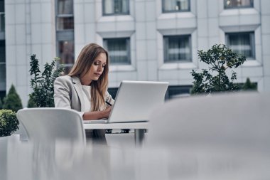 modern restoranda otururken dizüstü bilgisayar kullanan güzel genç kadın