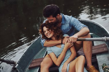 mutlu çift kucaklayan ve gölde tekne üzerinde romantik tarih tadını çıkarırken gülümseyen 