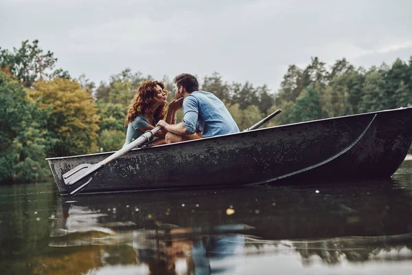 stock image young couple kissing while rowing a boat