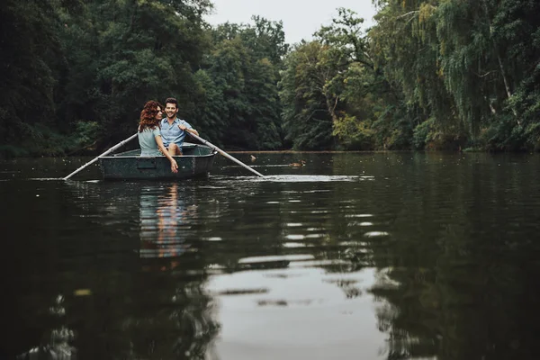 木と森の湖の自然の景色を楽しみながらボートで恋人同士 — ストック写真