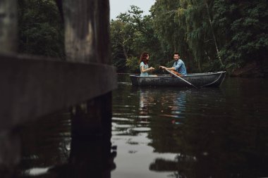 Çift botla göl kenarında romantik tarih tadını çıkarırken rahatlatıcı 
