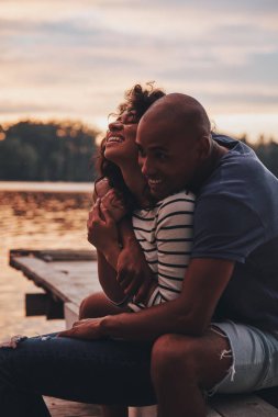 kucaklayan ve göl iskelede oturup aşık romantik çift 