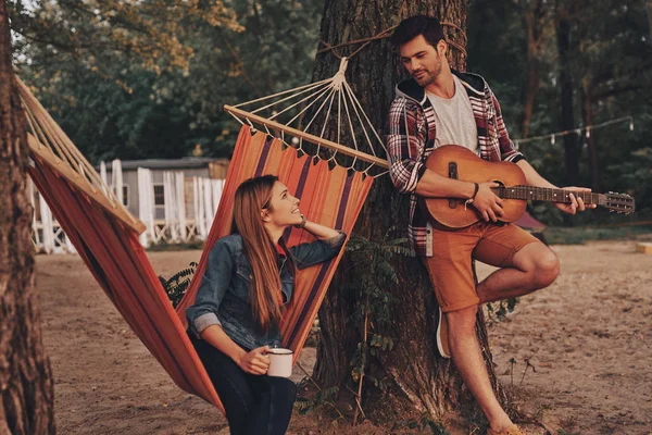 Stilig Ung Man Spela Gitarr För Vackra Flickvän Utomhus Skogen — Stockfoto