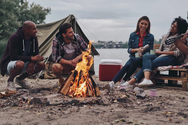 Щасливі Друзі Сидять Розмовляють Під Час Пожежі Відпочиваючи Біля Озера — стокове фото