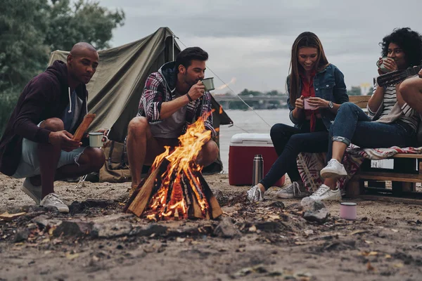 Φίλοι Καθισμένος Και Μιλήσει Στο Campfire Ζεστά Ροφήματα Κύπελλα — Φωτογραφία Αρχείου