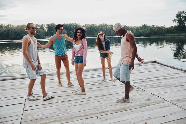 川で木製の桟橋上で楽しんで若者の全長 — ストック写真