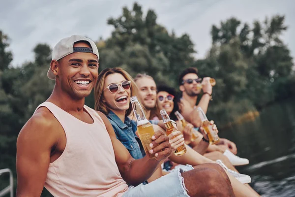 Skrattande Ungdomar Fritidskläder Leende Och Hålla Medan Sitter Piren Vid — Stockfoto