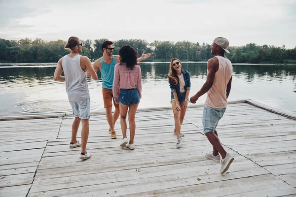 川で木製の桟橋上で楽しんで若者の全長 — ストック写真