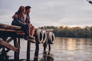 Göl iskelede oturup aşık romantik çift 