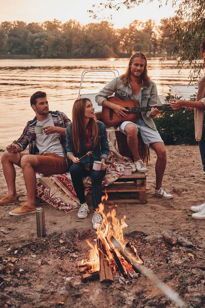 Giovani Abbigliamento Casual Godendo Campeggio Vicino Lago Tramonto Uomo Suonare — Foto Stock