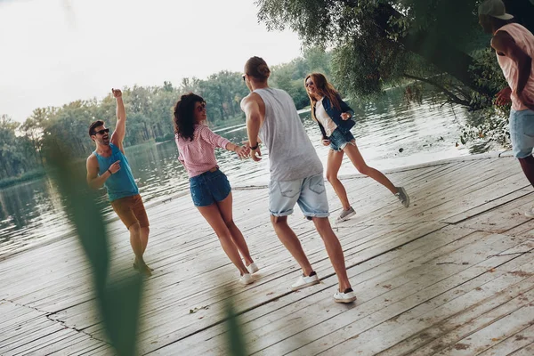 楽しい時を過すと川で木製の桟橋で実行されている幸せな人 — ストック写真