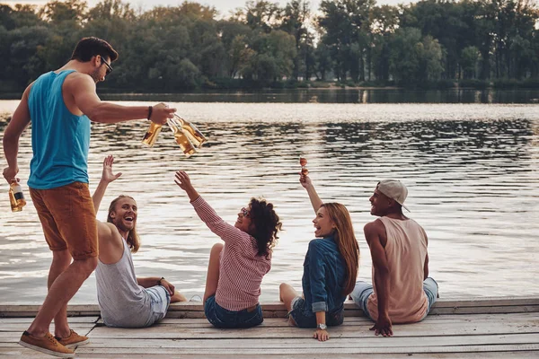 Risos Jovens Uso Casual Sorrindo Segurando Cerveja Enquanto Sentado Cais — Fotografia de Stock