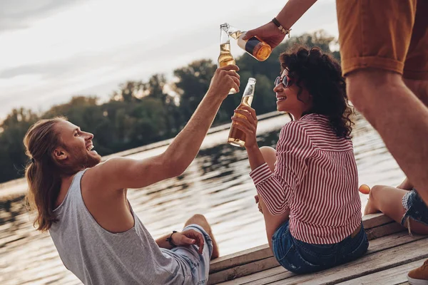 Ungdomar Fritidskläder Leende Och Spottar Med Ölflaskor Sittande Piren Vid — Stockfoto