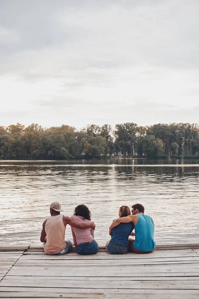 若い人々 は木製の桟橋に座っての背面図 — ストック写真