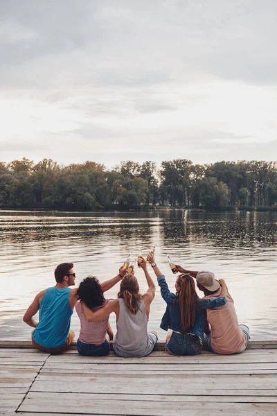 Rear View Friends Sitting Wooden Pier Cheering Beer Bottles — Stock Photo, Image