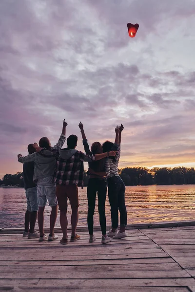 Beste Freunde Auf Hölzernem Steg Und Fliegendem Roten Herz Laternen — Stockfoto