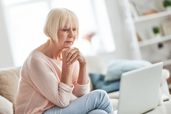 Serious Senior Caucasian Woman Sitting Sofa Home Looking Laptop Monitor — Stock Photo, Image