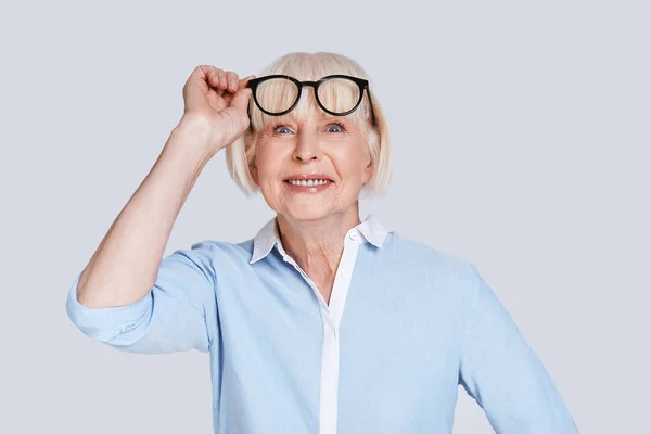 Şık Gözlük Ayarlama Kameraya Arıyor Gri Arka Plan Beyaz Kadın — Stok fotoğraf